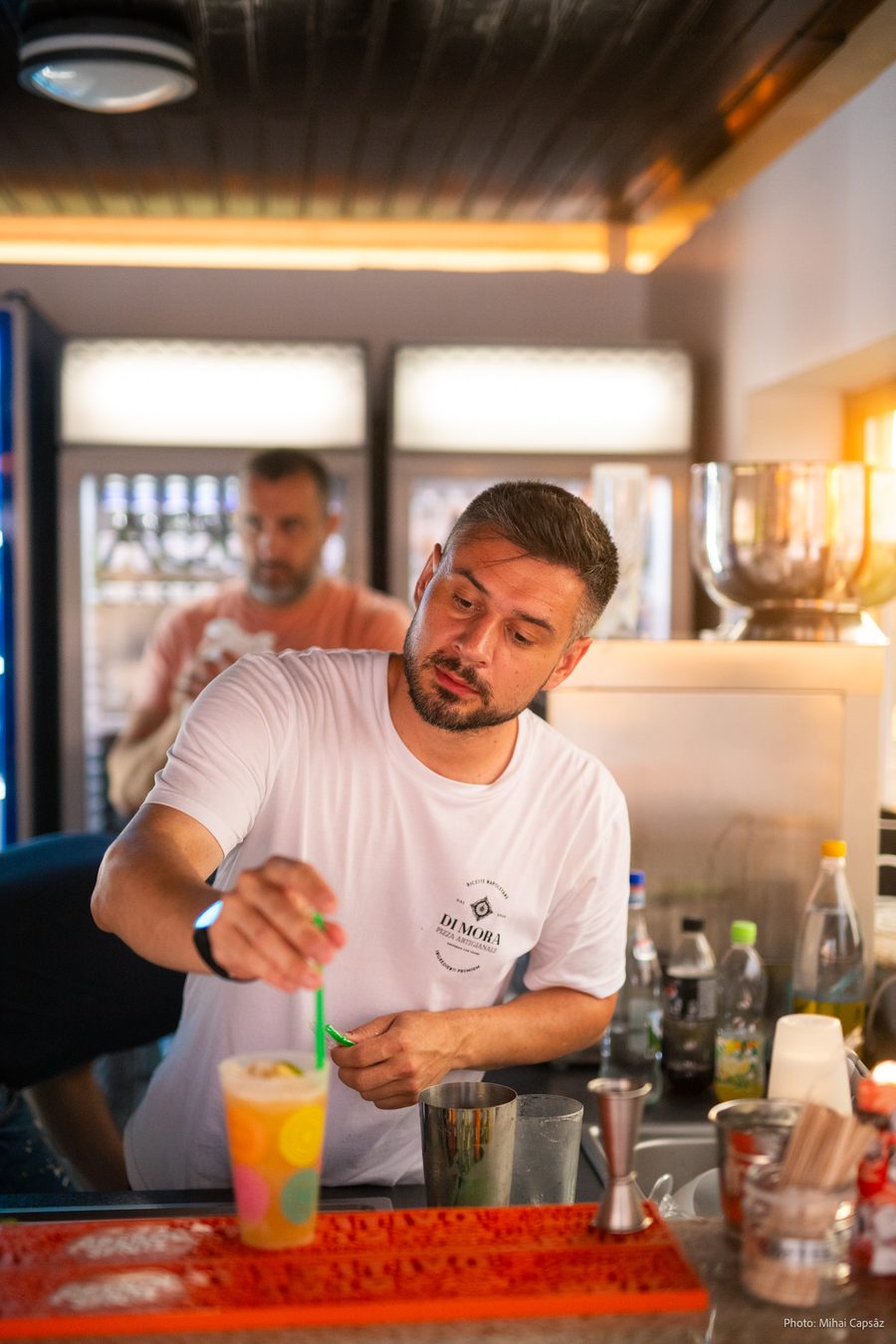 Barman care prepară un cocktail