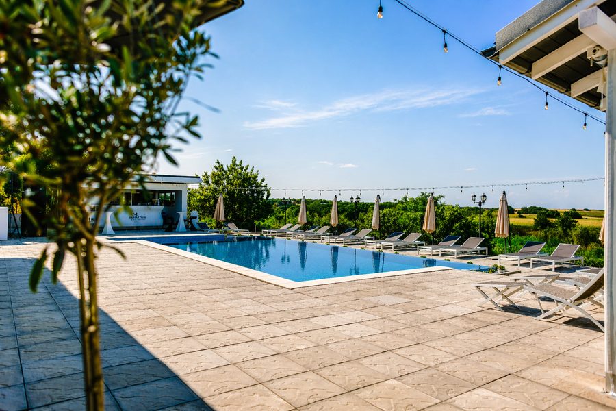 Piscina cu șezlonguri și umbrele într-o zi însorită de vară