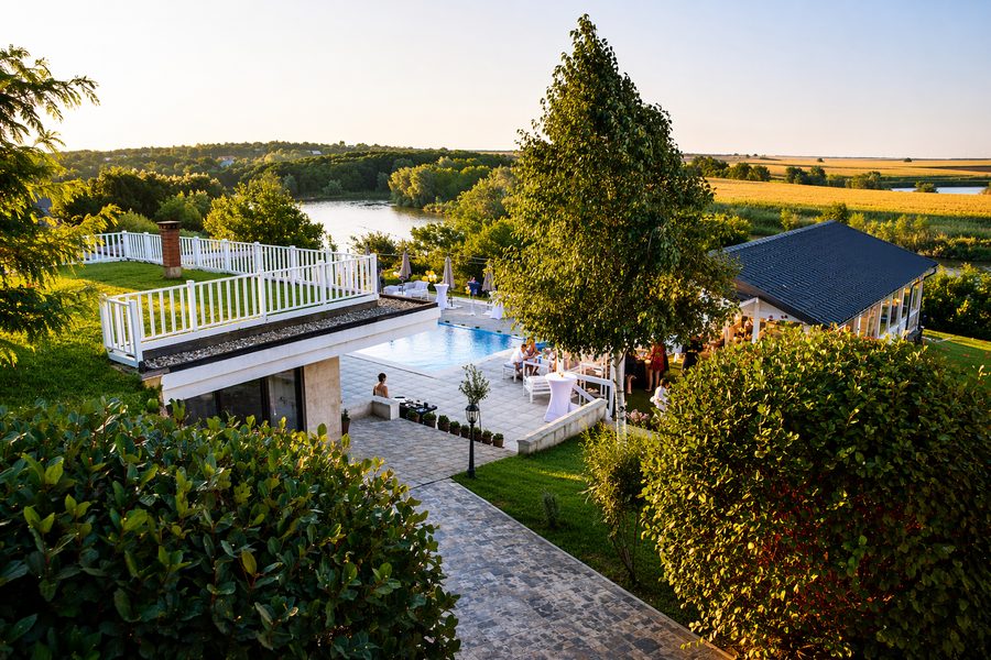 Piscina și terasa cu balustradă albă, cu vedere spre lac