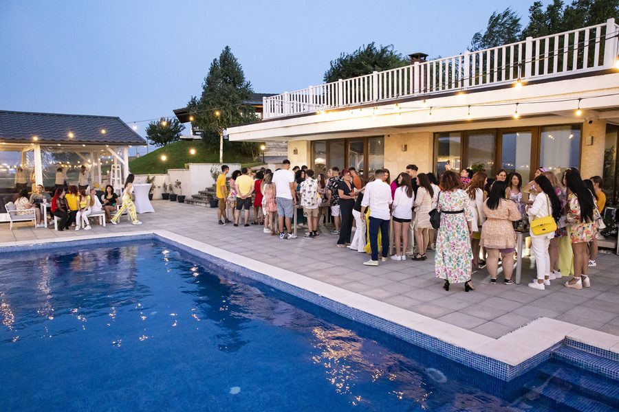Participanți adunați seara pe terasa de lângă piscina Elysion View
